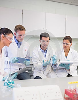 Scientists with tablet PC working on an experiment at lab