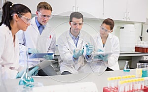 Scientists with tablet PC working on an experiment at lab