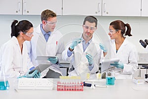 Scientists with tablet PC working on experiment at lab