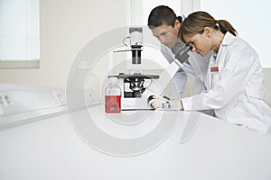 Scientists Using Microscope In Laboratory