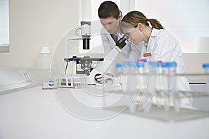 Scientists Using Microscope In Laboratory