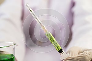 Scientists wearing masks and gloves Holding a syringe with a vaccine to prevent covid-19