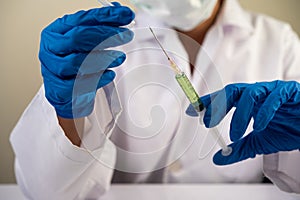 Scientists wearing masks and gloves Holding a syringe with a vaccine to prevent covid-19