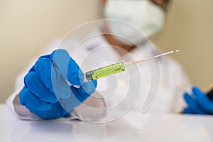 Scientists wearing masks and gloves Holding a syringe with a vaccine to prevent covid-19