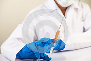 Scientists wearing masks and gloves Holding a syringe with a vaccine to prevent covid-19