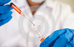 Scientists wearing masks and gloves Holding a syringe with a vaccine to prevent covid-19