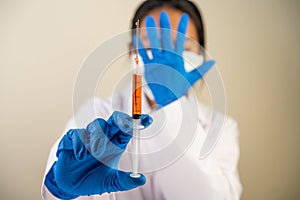 Scientists wearing masks and gloves Holding a syringe with a vaccine to prevent covid-19