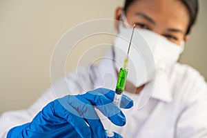 Scientists wearing masks and gloves Holding a syringe with a vaccine to prevent covid-19