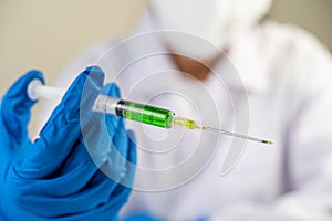 Scientists wearing masks and gloves Holding a syringe with a vaccine to prevent covid-19