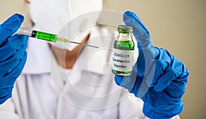 Scientists wearing masks and gloves Holding a syringe with a vaccine to prevent covid-19