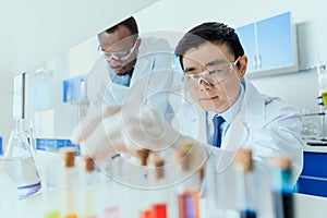 Scientists in white coats working together in chemical laboratory