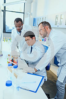 Scientists in white coats working together in chemical laboratory