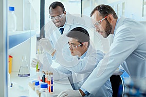 Scientists in white coats working together in chemical laboratory