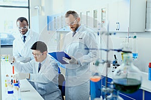 Scientists in white coats working together in chemical laboratory