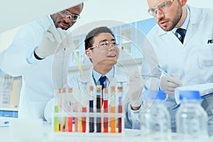 Scientists in white coats working together in chemical laboratory