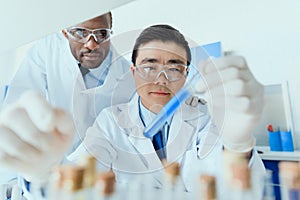 Scientists in white coats working together in chemical laboratory