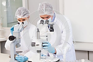 Scientists working attentively with microscopes