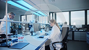 Scientists Working in Modern Laboratory with Microscopes and Computers Analyzing Data