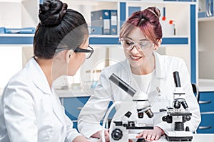 Scientists working together with microscopes in chemical lab