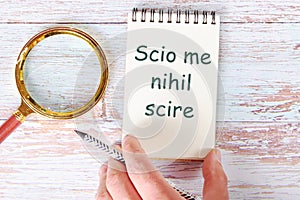 Scio me nihil scire It is translated from Latin as I know I don't know anything. It is written in a clean open notebook photo