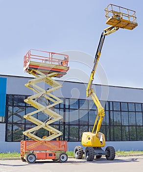 Scissor and articulated boom wheeled lifts on asphalt ground