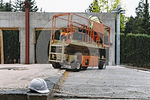 Scissor Lift Platform on a construction site near the wall