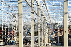 Scissor platforms and telescopic crane for the assembly of metal structural frames in a new building