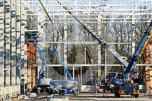 Scissor platforms and telescopic crane for the assembly of metal structural frames in a new building