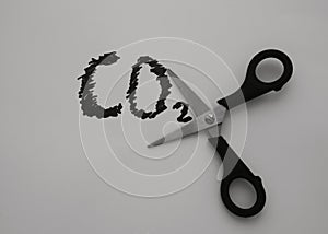 A scissor on a sheet of a paper cuts an inscription, CO2. Carbon dioxide reduction concept