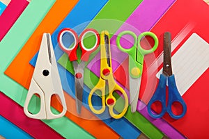 Scissors on background of colored school notebooks