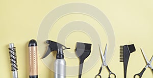 Scissors, comb and other hair styling tools on yellow background