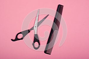 Scissors and comb on a pink background, hairdresser toolsn