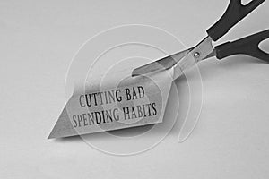 Scissors that cut yellow notepad with text on a black and white background