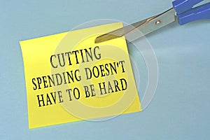 Scissors that cut yellow notepad with text on a blue background
