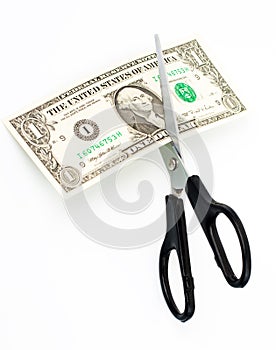 Scissors cuts one american dollar note