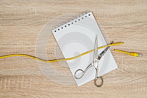 Scissors cutting data cable over a blank spiral notebook