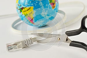 Scissors cutting internet cable with planet earth on white background - Concept of global internet outage photo