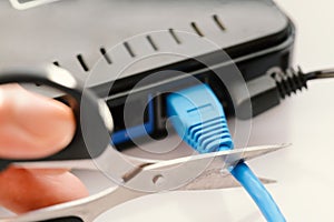 Scissors cutting LAN cable.