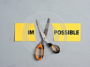 Scissors Cutting off the Word impossible and transforming into possible. Concept of possibility, positive thinking, confidence,