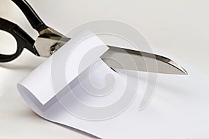 Scissors cutting paper over white background