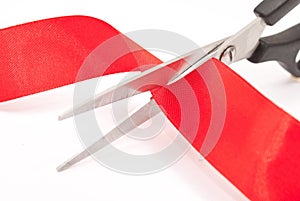 Scissors cutting red ribbon