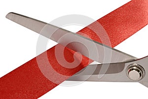 Scissors cutting red ribbon or tape, isolated on white, close up