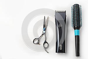 Scissors, hair clipper and combs on white background.