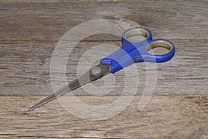 Scissors isolated on wooden background - close-up