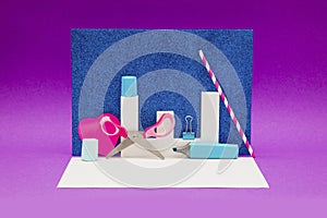 Scissors, marker and other decorations on a purple and shiny blue background