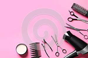 Scissors and other hairdresser`s accessories on pink background, flat lay. Space for