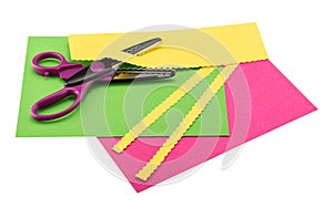 Scissors, paper edgers, lying on color construction paper