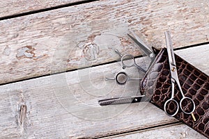 Scissors of professional barber on wooden background.