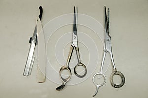 Scissors and razor blades on white table