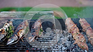 Scomber fishes and pork meat shashlik on grill. Smoke rising from fireplace
